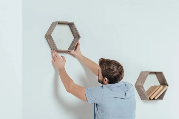 Casual jeune bricoleur suspendu bibliothèque en bois à la maison — Photo de stock