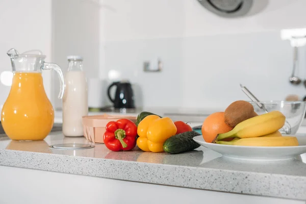 Frutta, verdura e succo d'arancia con latte sul tavolo della cucina — Foto stock