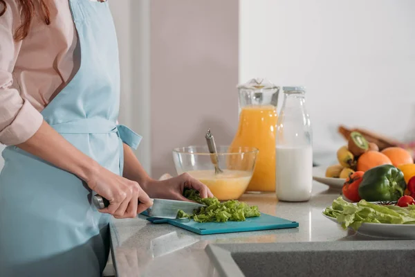 Immagine ritagliata di donna che taglia verdure per insalata — Foto stock