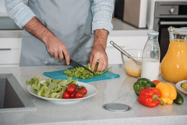 Cropped image of man cutting vegetables — Stock Photo