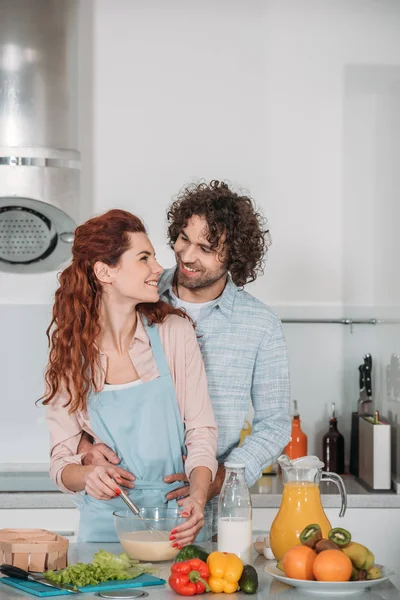 Novio abrazando novia mientras ella preparación bateador — Stock Photo