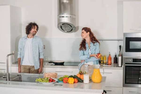 Couple heureux debout à la cuisine et en se regardant — Photo de stock