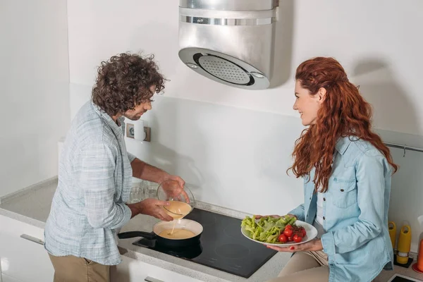 Fidanzato versando pastella sulla padella — Foto stock