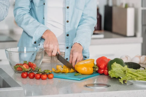 Abgeschnittenes Bild einer Frau, die Gemüse für Salat schneidet — Stockfoto