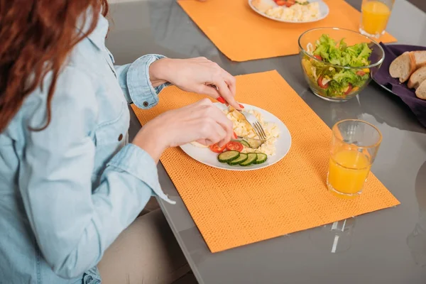 Обрізане зображення жінки, що їсть за столом на кухні — стокове фото
