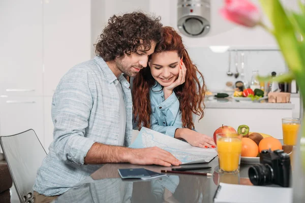 Pareja de viajeros planeando un viaje y mirando el mapa - foto de stock