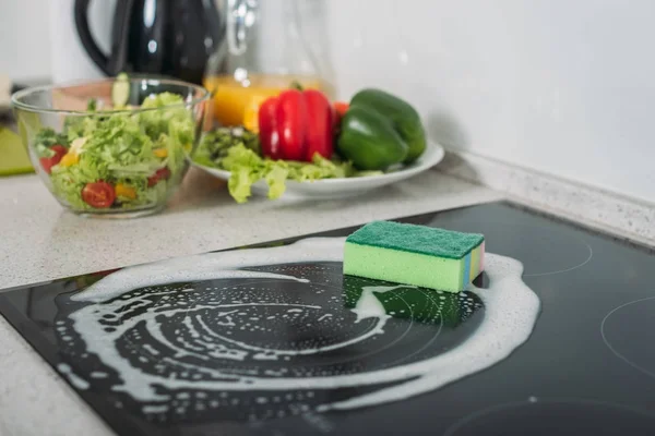 Schwamm und Seife auf Küchenherd reinigen — Stockfoto