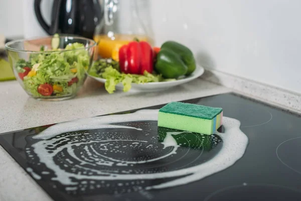 Cleaning sponge and soap on kitchen stove — Stock Photo