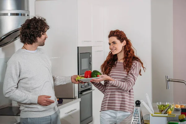 Novia dando novio plato con verduras - foto de stock