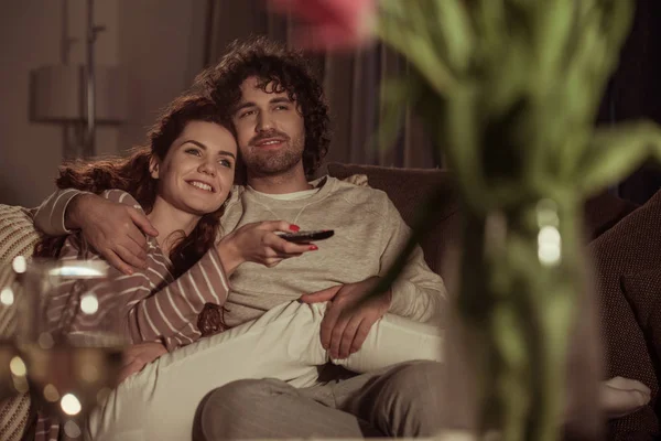 Casal feliz assistindo tv no sofá à noite — Fotografia de Stock