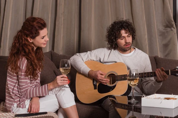 Guapo novio jugando canción con guitarra para sonreír novia - foto de stock