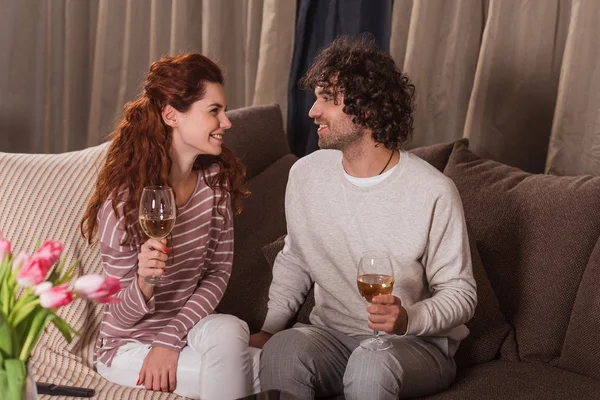 Casal feliz segurando copos com vinho e olhando um para o outro — Fotografia de Stock