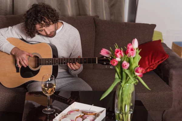 Bel homme jouant de la guitare à la maison — Photo de stock