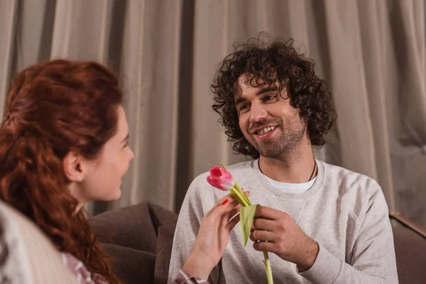 Smiling boyfriend presenting tulip to girlfriend — Stock Photo