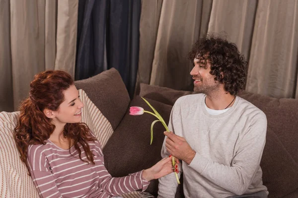 Smiling boyfriend presenting tulip to girlfriend — Stock Photo