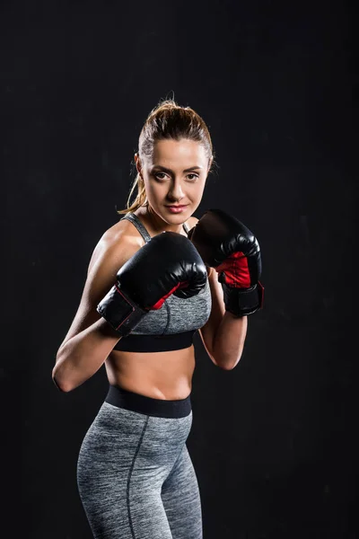Young female boxer smiling at camera isolated on black — Stock Photo