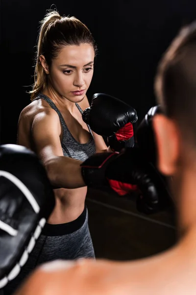 Selektiver Fokus der jungen Sportlerin beim Boxen mit hemdslosem Sportler — Stockfoto