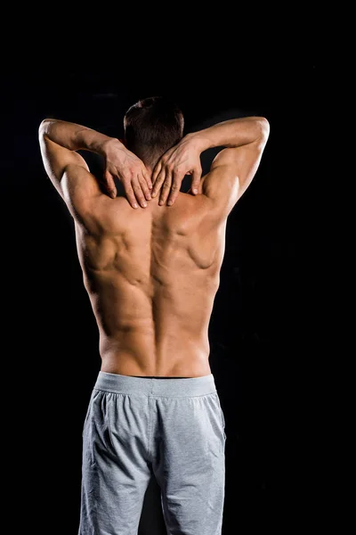 Visão traseira do atleta sem camisa muscular em pé isolado no preto — Fotografia de Stock