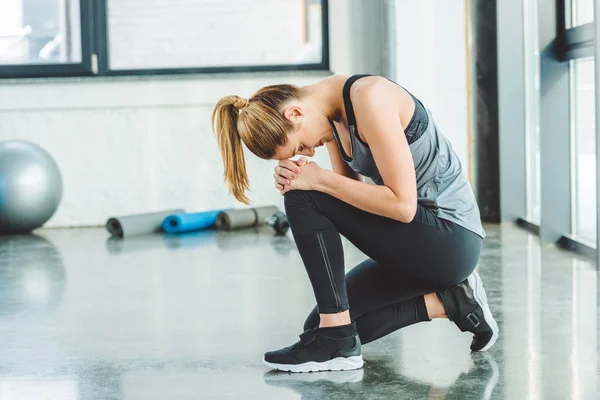 Side view of young caucasian woman in sportswear in gym — Stock Photo