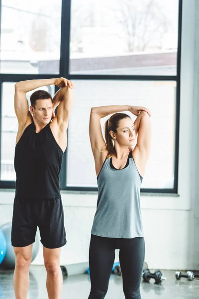 Porträt eines jungen Paares beim Aufwärmen vor dem Training im Fitnessstudio — Stockfoto