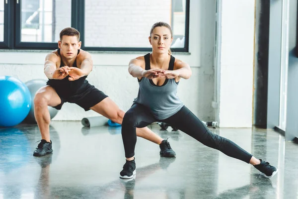 Caucasian man and woman training in gym together — Stock Photo