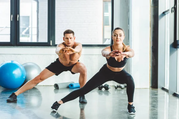 Caucásico hombre y mujer entrenamiento en gimnasio juntos - foto de stock