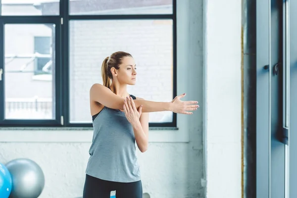 Portrait de jeune sportive échauffant avant l'entraînement en salle de gym — Photo de stock