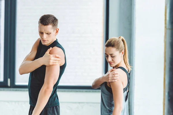 Junges Paar dehnt sich vor dem Training im Fitnessstudio — Stockfoto