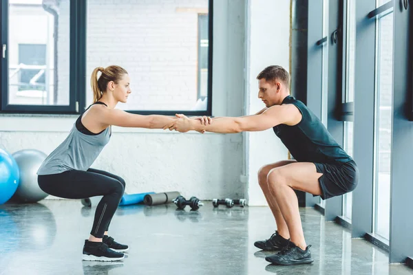 Side view of caucasian man and woman training in gym together — Stock Photo