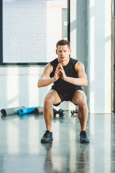 Concentré jeune sportif travaillant dans la salle de gym — Photo de stock