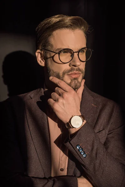 Porträt eines nachdenklichen, gut aussehenden jungen Mannes mit Brille, der wegschaut — Stockfoto