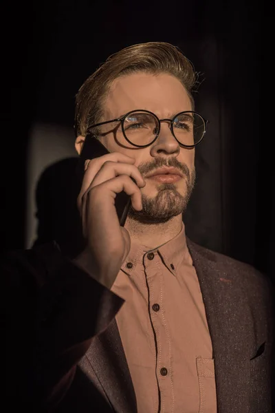 Красивий стильний молодий чоловік в окулярах говорить на смартфоні — стокове фото