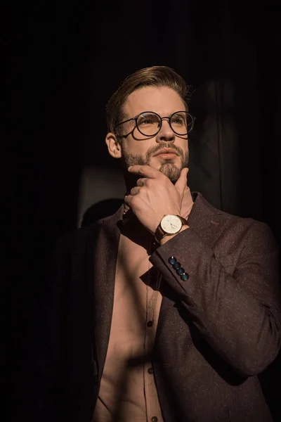 Portrait of pensive stylish bearded man with hand on chin looking away — Stock Photo