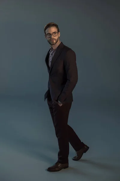 Full length view of handsome young man in smart suit posing in studio — Stock Photo