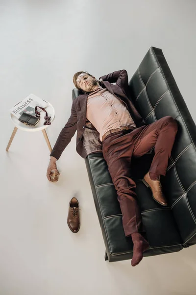 Vue grand angle de jeune homme d'affaires sans une chaussure dormir sur le canapé — Photo de stock