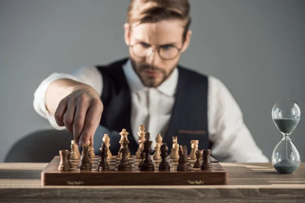 Selective focus of focused young businessman playing chess — Stock Photo