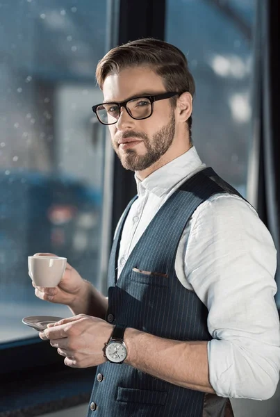 Porträt eines stylischen jungen Geschäftsmannes mit Brille, der Kaffee trinkt — Stockfoto