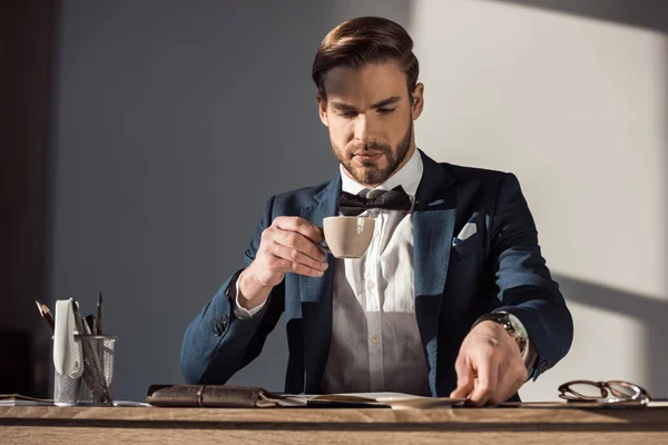 Stilvoller Jungunternehmer trinkt Kaffee am Arbeitsplatz — Stockfoto