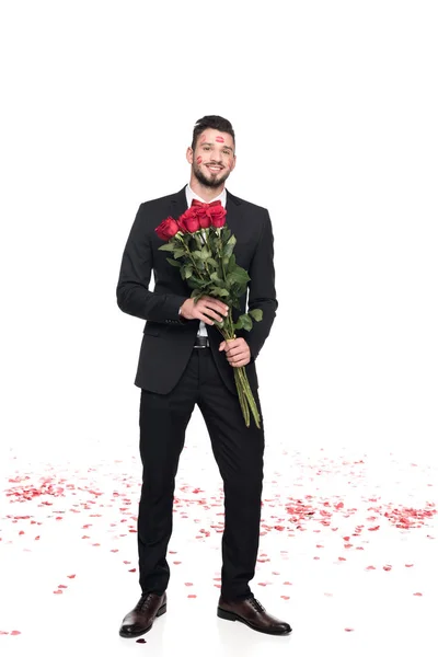 Man with lips traces on face holding bouquet of roses isolated on white, valentines day concept — Stock Photo