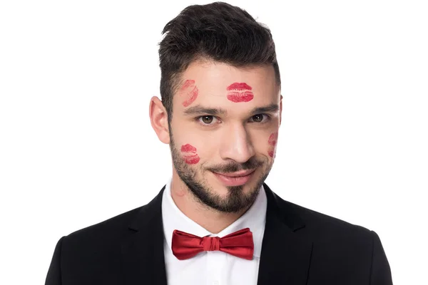 Lächelnder schöner Mann mit Lippenspuren im Gesicht isoliert auf weißem Grund — Stockfoto