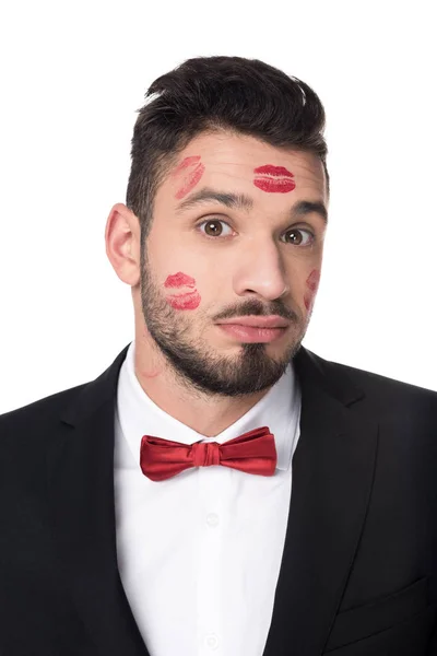 Bel homme avec des traces de lèvres sur le visage isolé sur blanc — Photo de stock