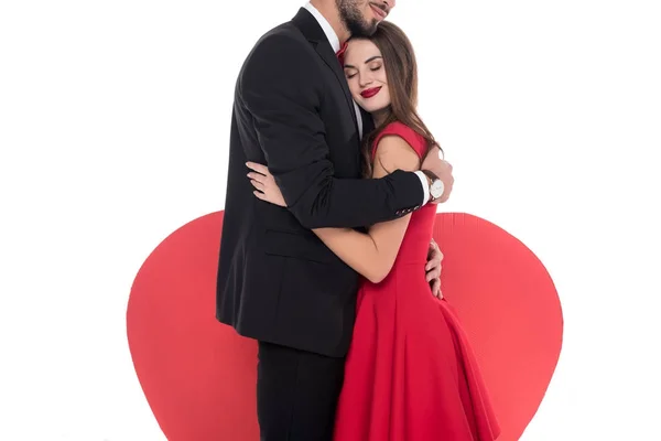 Imagen recortada de pareja abrazándose cerca de gran corazón aislado en blanco, San Valentín concepto de día - foto de stock