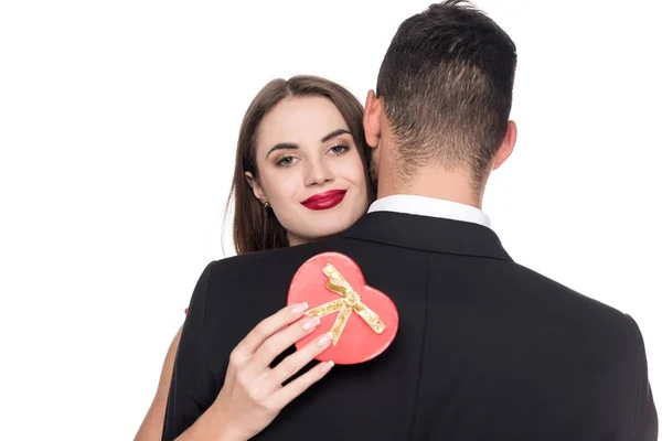 Novia abrazando novio y sosteniendo rojo presente caja aislado en blanco, San Valentín concepto de día - foto de stock