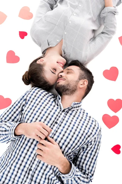 Overhead view of couple lying with paper hearts isolated on white, valentines day concept — Stock Photo