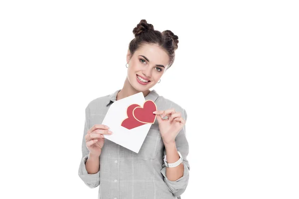 Menina sorrindo segurando cartão postal Valentim e envelope isolado no branco — Fotografia de Stock