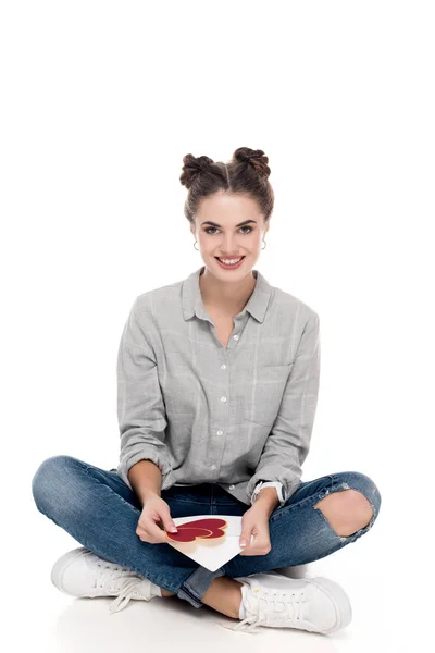 Smiling girl holding valentines postcard and envelope on white — Stock Photo