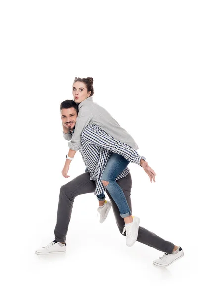 Side view of boyfriend giving piggyback to girlfriend isolated on white — Stock Photo