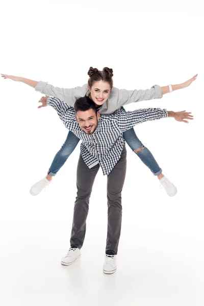 Namorado dando piggyback para namorada com os braços abertos isolados no branco — Fotografia de Stock