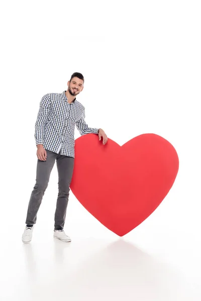 Schöner Mann stützt sich auf großes Herz auf weißes, valentines Day-Konzept — Stockfoto