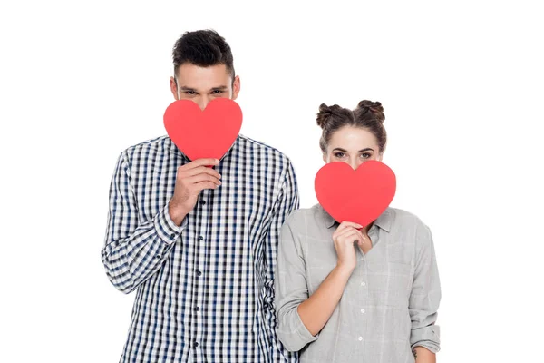 Pareja cubriendo bocas con corazones de papel aislados en blanco, San Valentín concepto de día - foto de stock